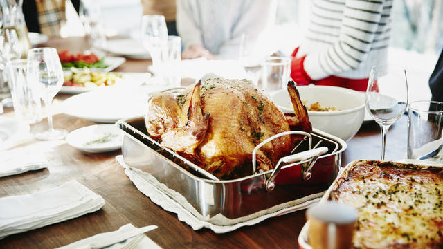 Turkey in roasting pan on table for holiday meal 