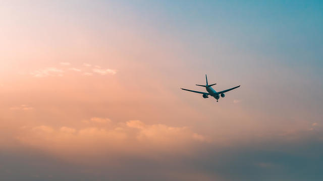 Low angle view of airplane flying in sky during sunset,Romania 