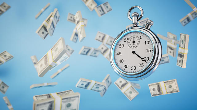 limited time to earn money. a stopwatch and packs of dollar bills flying across a blue background. 3D render 