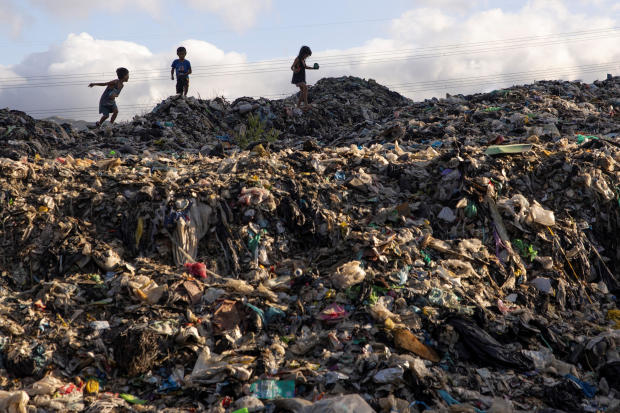 Children walk on a garbage dump filled with plastics in Rodriguez, Rizal province, Philippines, Nov. 28, 2024. 