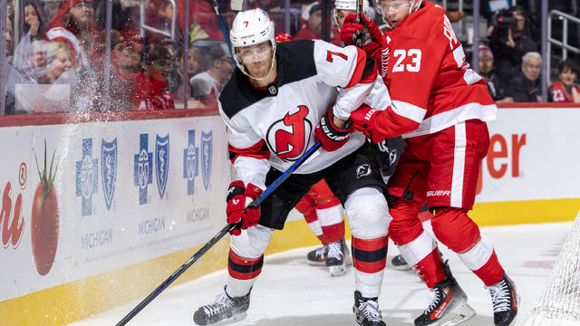 Dougie Hamilton (7) of the New Jersey Devils protects the puck from from Lucas Raymond (23) of the Detroit Red Wings during the third period at Little Caesars Arena on November 29, 2024 in Detroit, Michigan. 