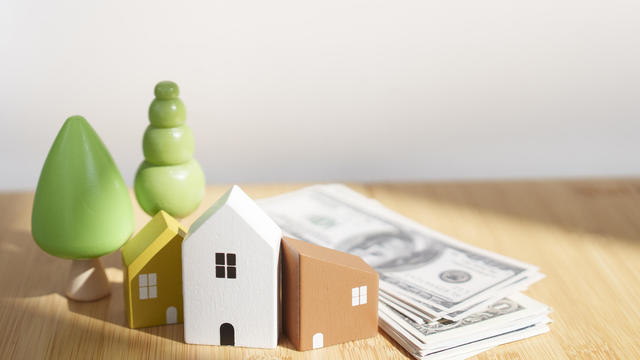 small wooden house  real estate with money cash on the bamboo table 