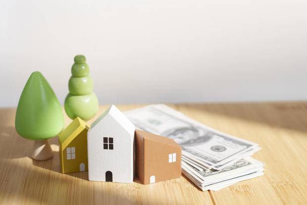 small wooden house  real estate with money cash on the bamboo table 