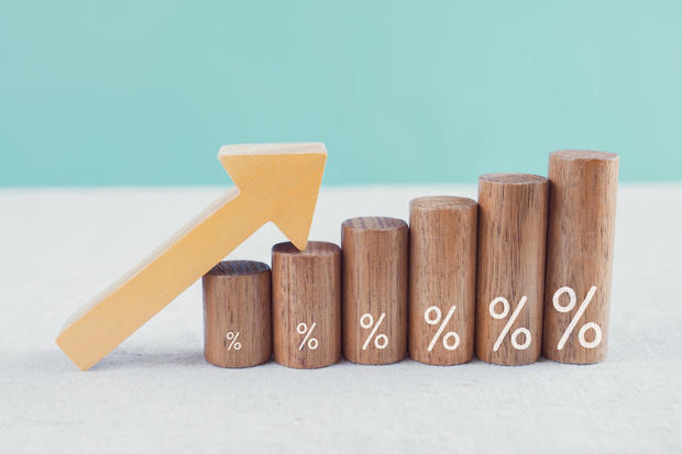 Wooden blocks with percentage sign and arrow up, financial growth, interest rate and mortgage rate increase, inflation concept 