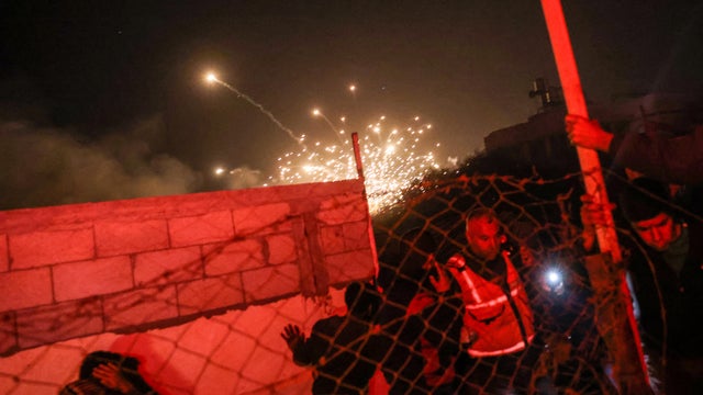 People run for cover as an explosion from an Israeli strike occurs near a makeshift camp for displaced Palestinians, in Mawasi Khan Yunis in the southern Gaza Strip on Dec. 4, 2024, amid the ongoing war between Israel and the Hamas militant group.