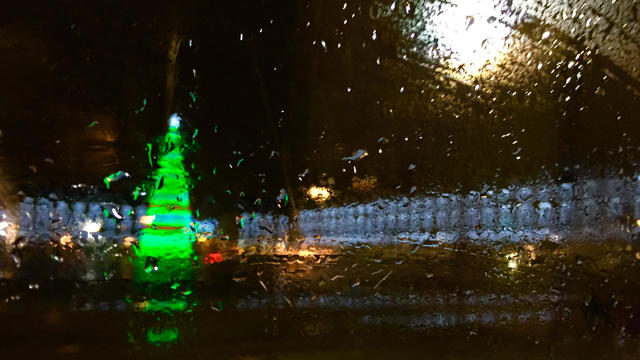 photo of a christmas tree through glass with raindrops 