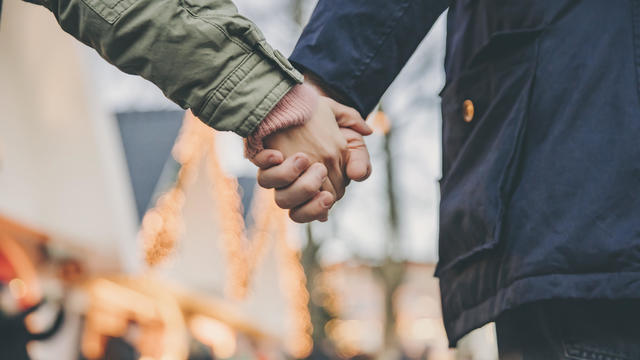 Close-up of couple holding hands on the Christmas Market 