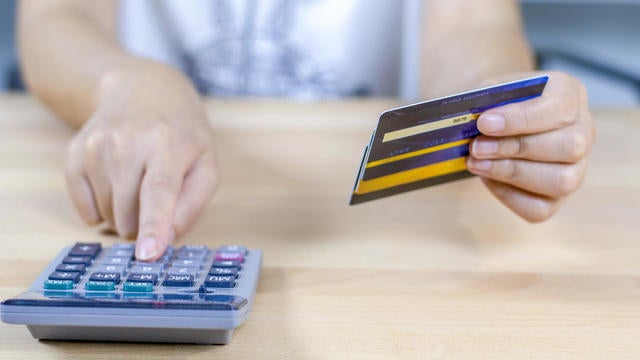 woman calculate how much cost have with credit cards. 