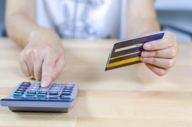 woman calculate how much cost have with credit cards. 