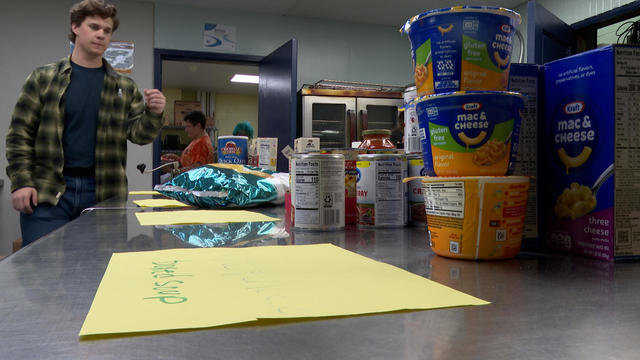 A student organizes food in the food pantry 