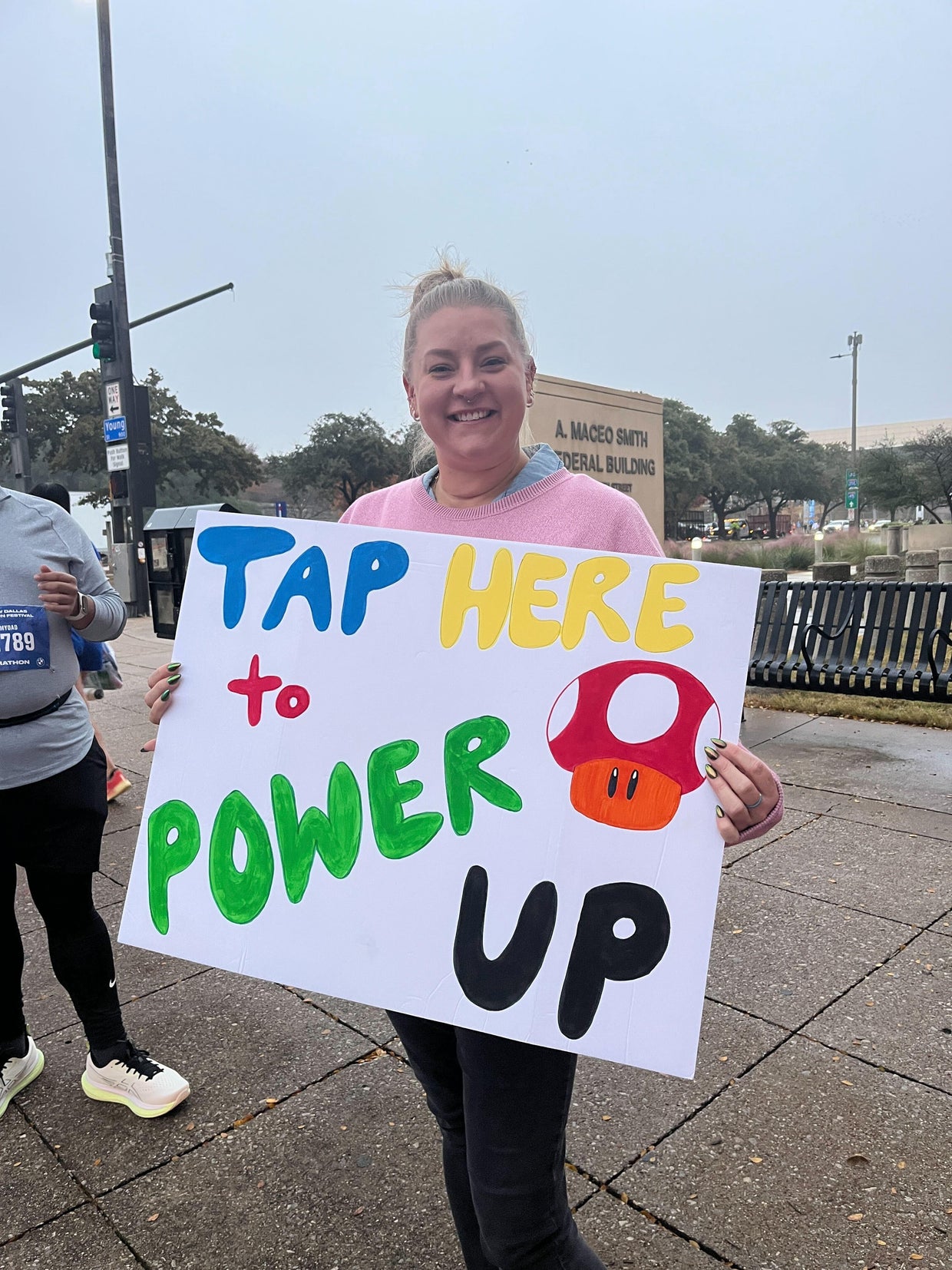 Fans cheer on runners with creative signs at the BMW Dallas Marathon