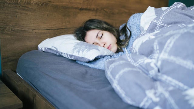 Young woman sleeping in bed at night 