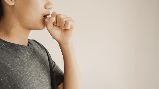 Close up of teen boy coughing from cold and flu,COPD, pneumonia, bronchitis, asthma, allergy, respiratory illness concept 