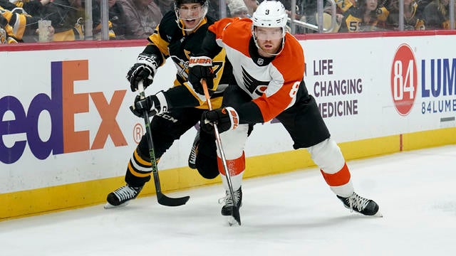 Pittsburgh Penguins' Sidney Crosby reaches for the puck against Philadelphia Flyers' Cam York during the second period of an NHL hockey game 