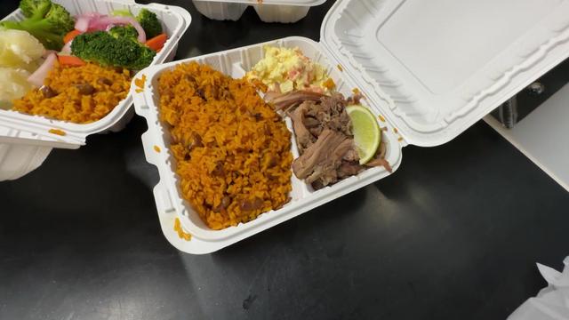 Pernil with rice and beans in a takeout container. 