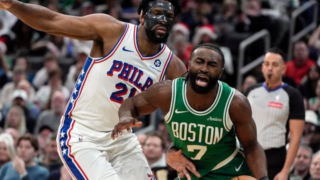 Celtics' Jaylen Brown drives past Philadelphia 76ers' Joel Embiid during the first half of an NBA basketball game in Boston 