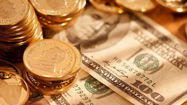 Gold coins with hundred dollar bills 