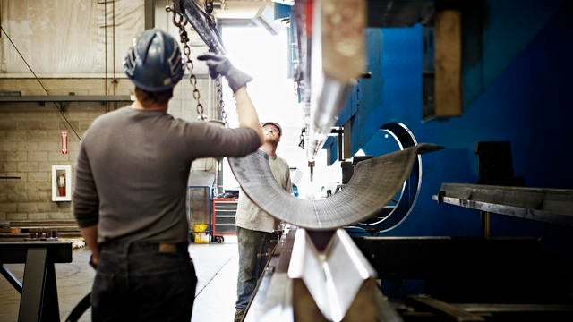 Steel workers adjusting position of steel 