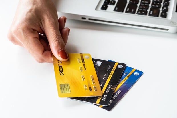 Cropped shot of someone hand with a set of cradit cards isolated on white table. 