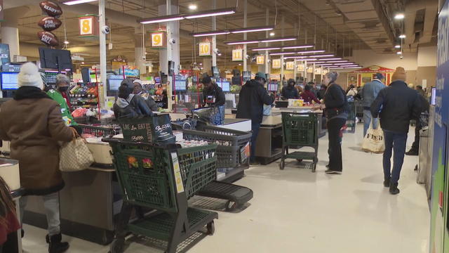 People check out at a grocery store ahead of a winter storm in Cheltenham 