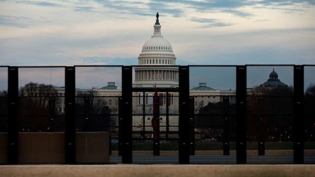 The U.S. Capitol building is seen through security fencing as workers install barricades on the National Mall on Jan. 5, 2025, in Washington, D.C. 