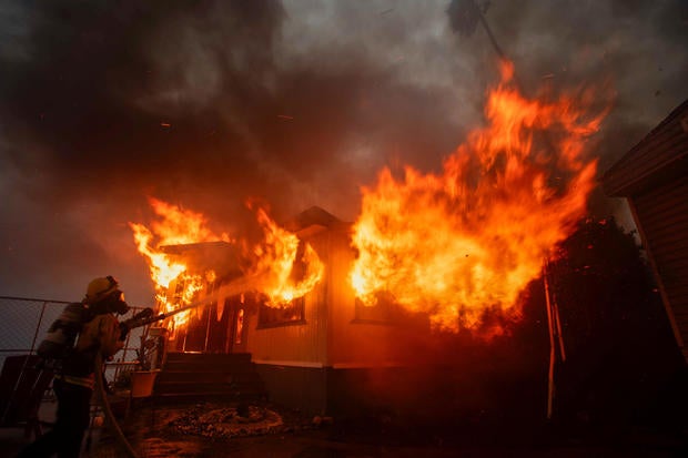 A firefighter battles the Palisades Fire during a windstorm on the west side of Los Angeles, California, Jan. 7, 2025. 