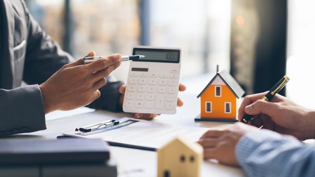 House model with agent and customer discussing for contract to buy, get insurance or loan real estate or property.