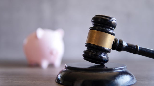 Closeup image of judge gavel and piggy bank. 