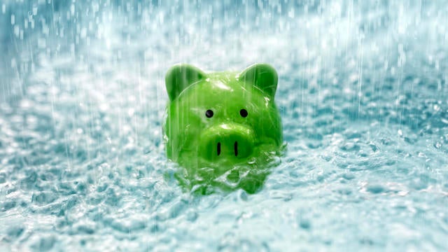 Piggy bank drowning in debt sinking in heavy rain water 