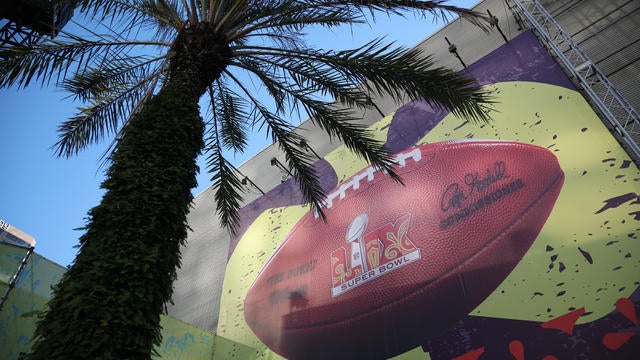 The Caesars Superdome is seen with a mural including a football and the Super Bowl LIX logo 