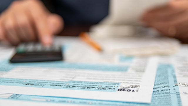 A man organizing individual income tax return form 1040 and receipts. Blurred background. Tax time.Tax concept. Close-up. 