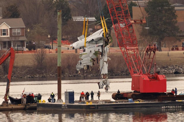 A crane retrieves part of the wreckage of American Eagle Flight 5342 from the Potomac River, in the aftermath of the deadly midair collision between the plane and an Army Black Hawk helicopter, by Ronald Reagan Washington National Airport, in Arlington, V 