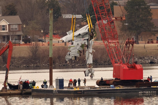 A crane retrieves part of the wreckage of American Eagle Flight 5342 from the Potomac River, in the aftermath of the deadly midair collision between the plane and an Army Black Hawk helicopter, by Ronald Reagan Washington National Airport, in Arlington, V