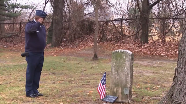 Rev. Floyd White III saluting a tombstone in the historic Butler Cemetery in Camden, New Jersey 