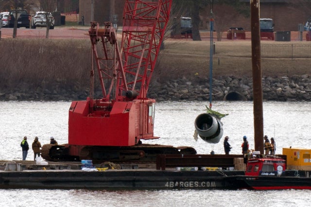 Rescue and salvage crews pull up a plane engine as cranes work near the wreckage of an American Airlines jet in the Potomac River from Ronald Reagan Washington National Airport, Feb. 3, 2025, in Arlington, Va.