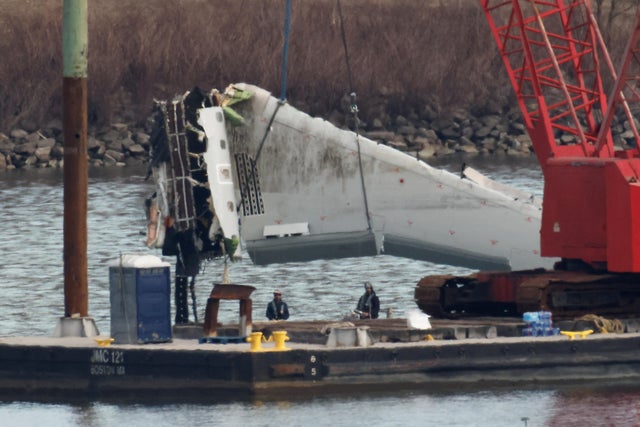 A crane retrieves a wing from the wreckage of American Eagle Flight 5342 in the Potomac River following the deadly midair collision with a Black Hawk helicopter, by Ronald Reagan Washington National Airport, in Arlington, Virginia, Feb. 3, 2025.
