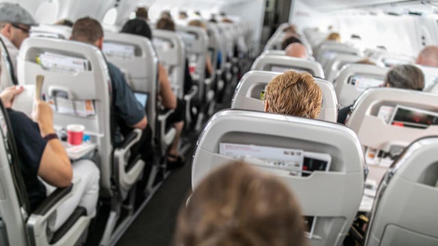 Interior of commercial airplane with passengers in their seats 