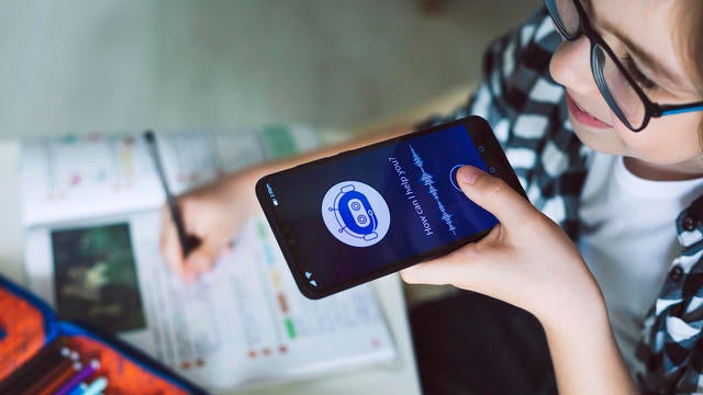 Smiling boy using system AI Chatbot on mobile application. Chatbot conversation, Ai Artificial Intelligence technology. Futuristic technology. Virtual assistant on internet. 