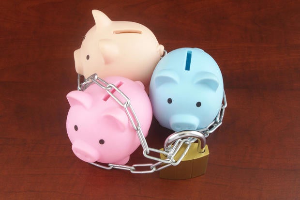 Three different piggy banks with chain and padlock. 