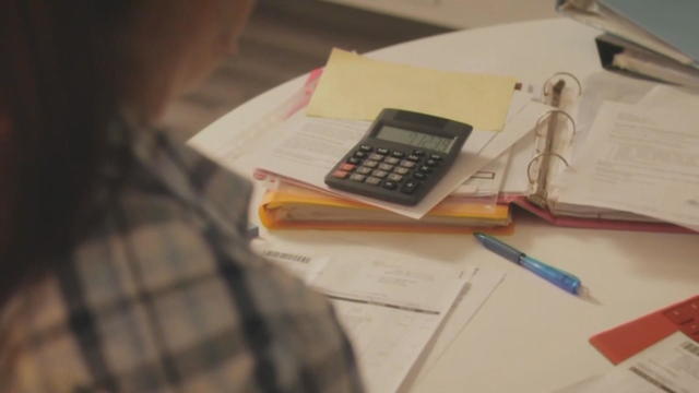 Papers and a calculator are seen as someone is preparing taxes 