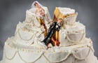 Bride and groom figurines collapsed at ruined wedding cake 