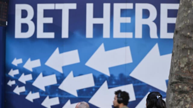 People passing by a BoyleSports betting office advertising board in Dublin city center 