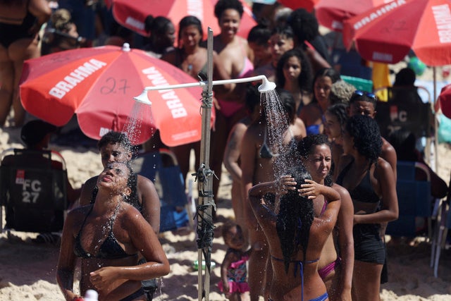 People cool off in showers during a heatwave at the Ipanema beach in Rio de Janeiro 