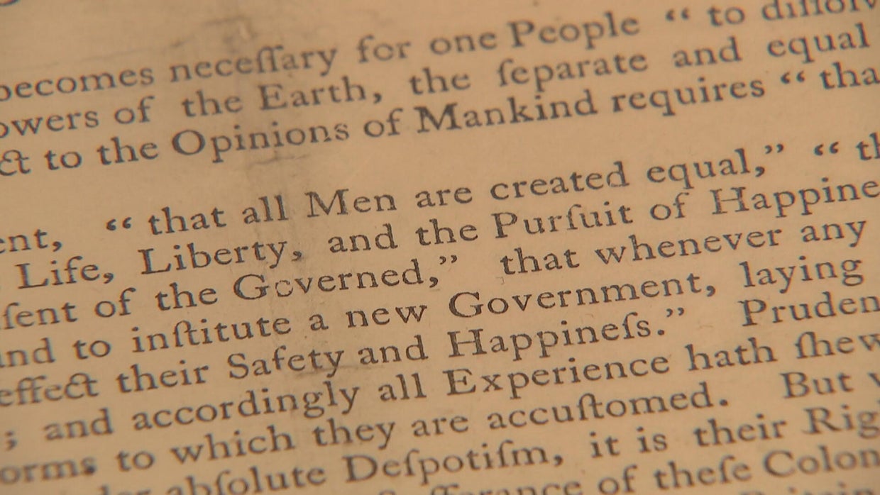 A close-up view of a draft of the Declaration of Independence, the phrase "all men are created equal" is in quotation marks 