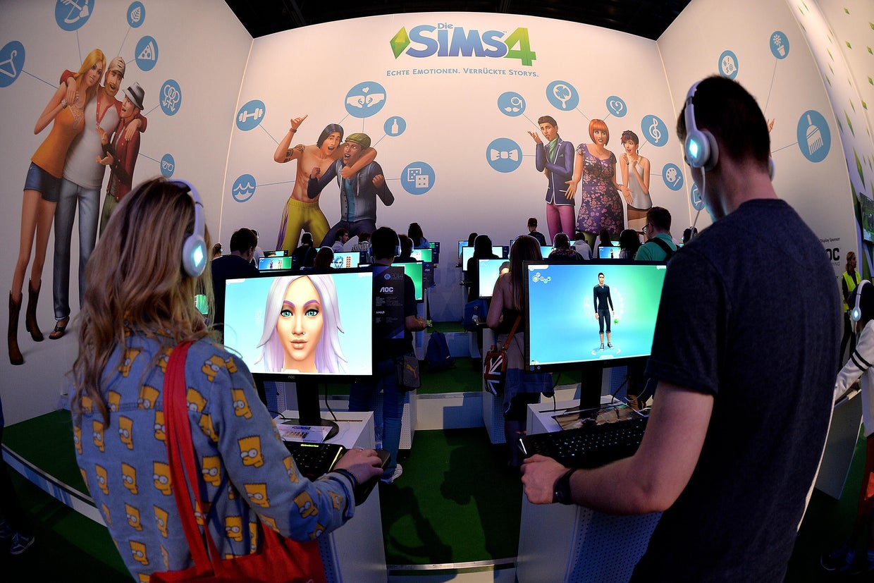 Visitors try out the game The Sims 4 at the Electronic Arts stand at the Gamescom gaming trade fair on Aug. 14, 2014, in Cologne, Germany. 