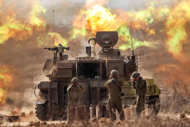 An Israeli army M109 155mm self-propelled howitzer fires rounds near the border with Gaza in southern Israel on Oct. 11, 2023. 