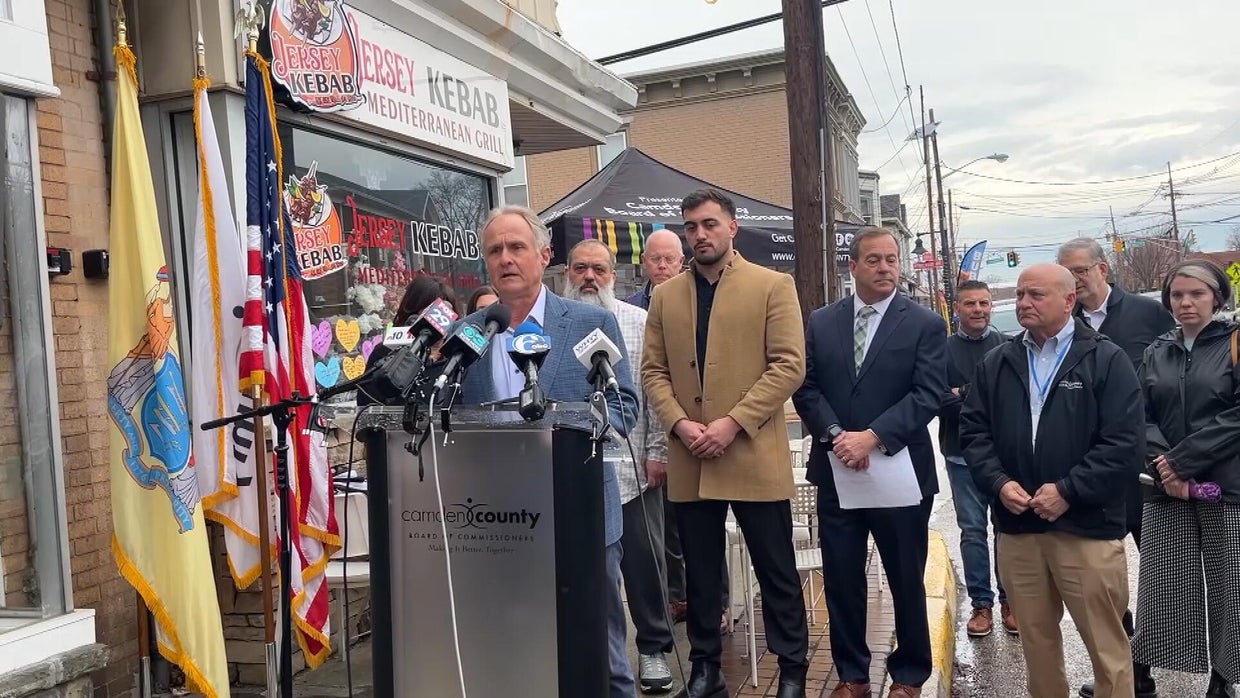 Members of the Emanet family and local leaders stand behind the podium at a news conference outside Jersey Kebab Thursday 