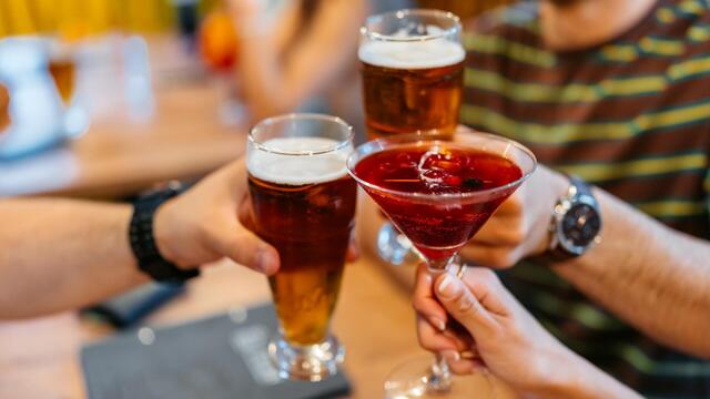 Group Of Friends Cheering With Cocktails And Beer In A Bar Indoors 