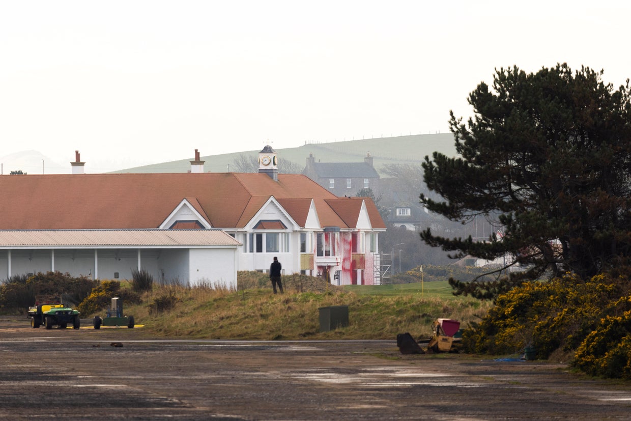 A man looks towards club house covered in red paint in the aftermath of a pro-Palestinian protest on U.S. President Trump's golf course in Turnberry 