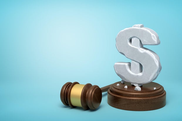 3d rendering of hefty stone dollar symbol standing on wooden sounding block with gavel beside on light-blue background with copy space.